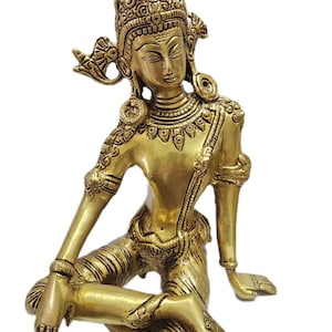 May include: A gold-colored brass statue of a seated deity with intricate details and a crown-like headdress.