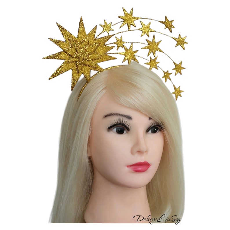 May include: Gold glitter starburst headband with a row of smaller gold glitter stars. The headband is a festive accessory for a party or special occasion.