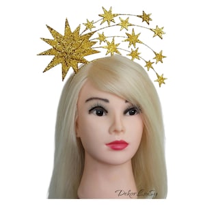 May include: Gold glitter star headband with a large star on the side and smaller stars in a curved line.