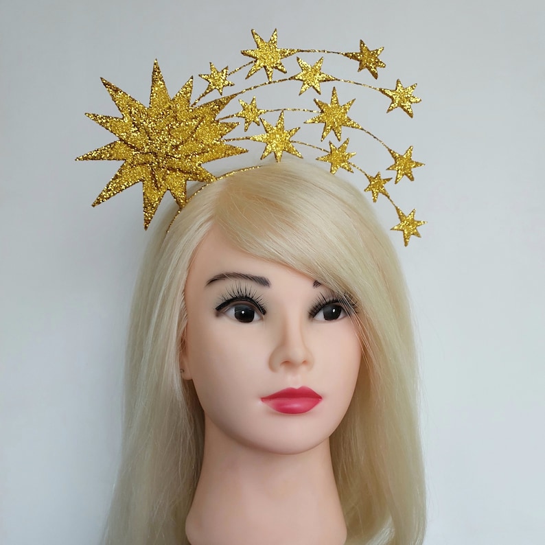 May include: A gold glitter starburst headband with a row of smaller gold glitter stars.