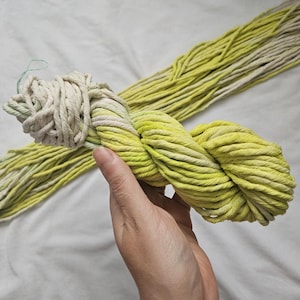May include: A skein of thick, hand-dyed cotton rope with a gradient of yellow and white.
