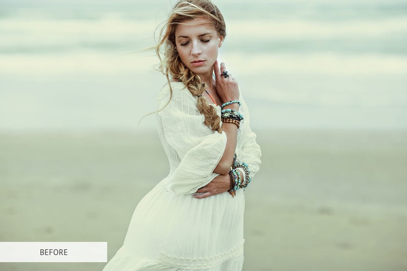May include: A woman with long blonde hair wearing a white dress and multiple bracelets on her wrist. She is standing on a beach with the ocean in the background.