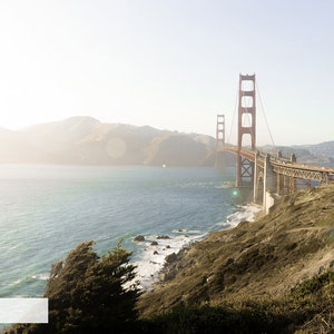 May include: A view of the Golden Gate Bridge in San Francisco, California. The bridge is red and has a large tower on each side. The bridge is over a body of water and there are hills in the background.