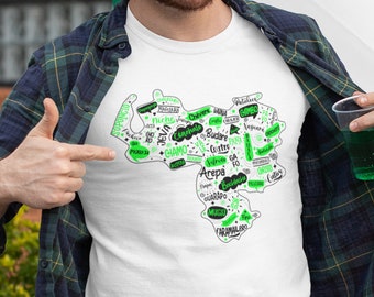 May include: White t-shirt featuring a green outline of Venezuela with words in Spanish, including "Arepa", "Chévere", "Jevá", "Niche", "Patuleco", "Sifrite", "Soponcio", and "Vainá".