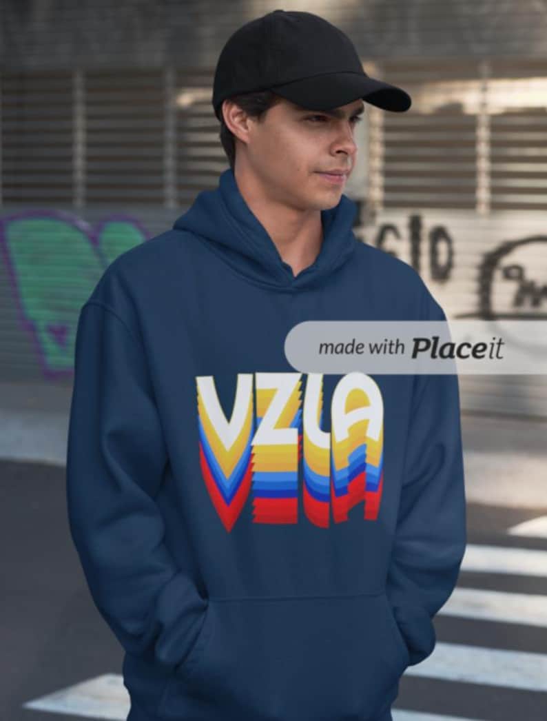 May include: A navy blue hoodie with a colorful retro-style graphic that says "VZLA".