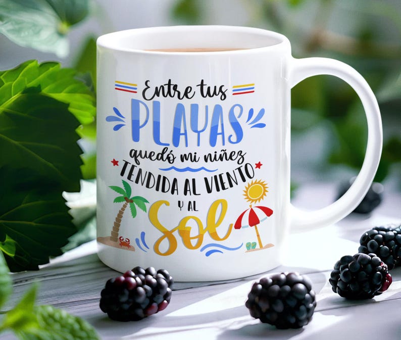 May include: White ceramic mug with a colourful design featuring the text "Entre tus PLAYAS qued&oacute; mi ni&ntilde;ez TENDIDA AL VIENTO y al SOL". The design includes a palm tree, a beach umbrella, and a sun.