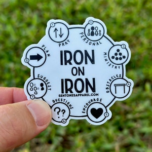 May include: A white circular sticker with black text and icons. The text reads "Iron on Iron" and "Sentonesapparel.com". The icons depict a plan, pray, personal, ministry, obstacles, suggest, questions, and encourage.