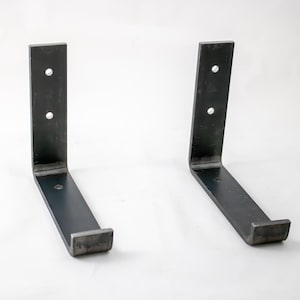 May include: Two black metal shelf brackets with a 90-degree angle. Each bracket has three holes for mounting.