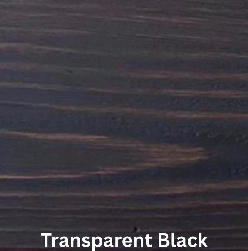 May include: Close-up of a wood grain pattern with a transparent black finish. The wood grain has a dark, almost black color with lighter brown streaks running horizontally across the surface. The text "Transparent Black" is at the bottom.