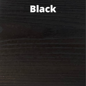 May include: Close-up of a black wood grain surface. The word "Black" is written in white text on the surface.