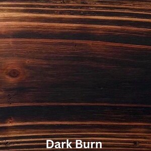May include: Close-up of a wood grain pattern with a dark brown, almost black, color. The wood grain has a textured appearance with visible lines and knots. The text "Dark Burn" is displayed at the bottom of the image.