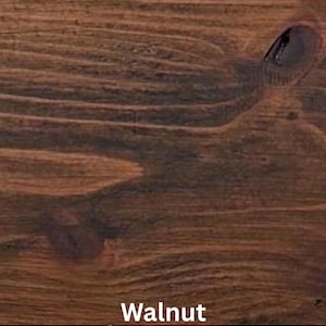 May include: Close-up of a stained wood surface with a rich, dark brown color. The wood grain is visible, with a knot and swirling patterns. The word "Walnut" is printed in white at the bottom of the image.