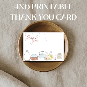 Może przedstawiać: Drukowana karta z podziękowaniami 4x6 z akwarelową ilustracją środków czyszczących. Karta zawiera napis "Thank You" w stylu odręcznym. Karta znajduje się w drewnianej misce na neutralnej lnianej powierzchni.