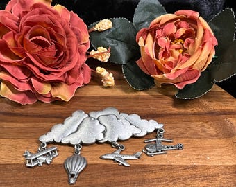 Broche vintage de Jonette: nubes de peltre en 3D con máquinas voladoras colgantes. Firmado por JJ.