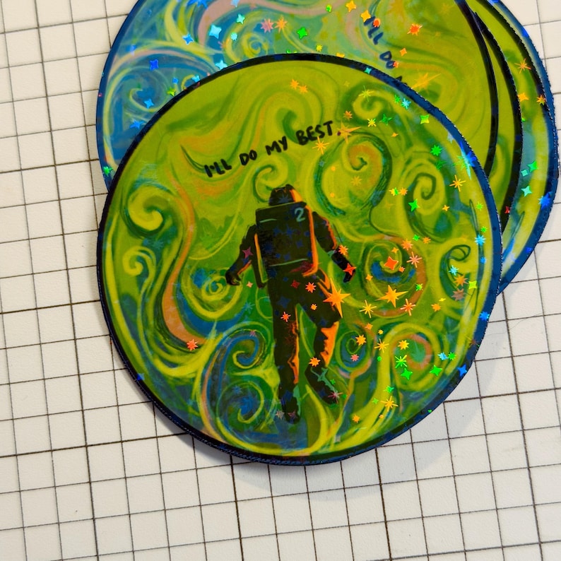 May include: Circular sticker with a vibrant design. The central image features an astronaut figure against a swirling green and yellow background. The text "I'll do my best" is visible. The sticker has a blue border and holographic accents.