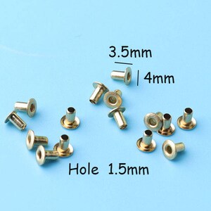 Puede incluir: Primer plano de 12 ojales metálicos de color dorado con un agujero de 1,5 mm. Los ojales tienen un diámetro de 3,5 mm y una altura de 4 mm.