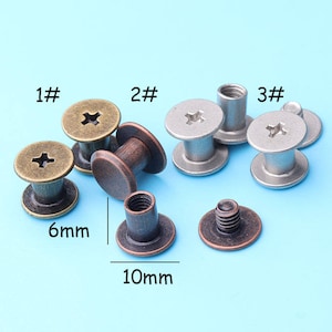 May include: A collection of metal rivets in various colors and styles, including bronze and silver. The rivets have a cross-shaped design on the heads and are 6mm and 10mm in size.