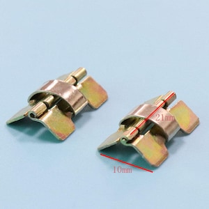 Op de afbeelding: Twee messingkleurige metalen scharnieren met een lengte van 21 mm en een breedte van 10 mm. De scharnieren zijn ontworpen om te vouwen en twee oppervlakken te verbinden.