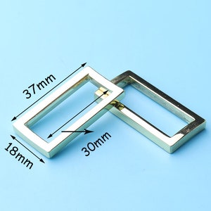 May include: Two gold-coloured metal rectangular rings, one slightly larger than the other, with measurements labelled in millimetres. The larger ring is 37mm by 30mm, and the smaller ring is 18mm by 30mm.