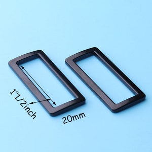 May include: Two black metal rectangular slider buckles, one measuring 1 1/2 inches and the other 20mm.
