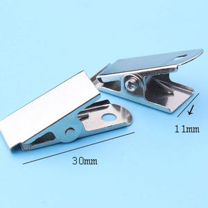 May include: Two silver metal clips, one is 30 mm long and 11 mm wide, the other is 30 mm long and 11 mm wide.
