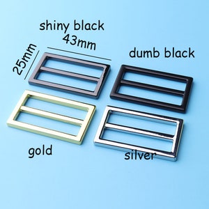 May include: Four metal slider buckles in different finishes: shiny black, dumb black, gold, and silver. The buckles are 4.3 cm long and 2.5 cm wide.