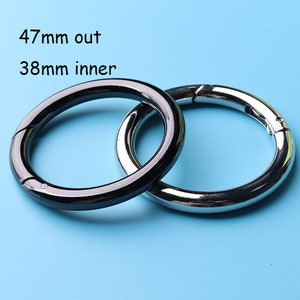 May include: Two metal key rings, one black and one silver, with a 47mm outer diameter and a 38mm inner diameter.