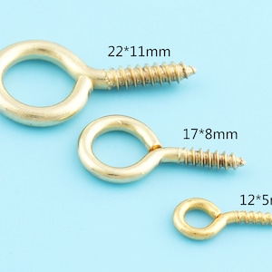 May include: Three gold-coloured screw-in eye hooks of different sizes. The largest hook measures 22mm by 11mm, the middle hook measures 17mm by 8mm, and the smallest hook measures 12mm by 5mm.