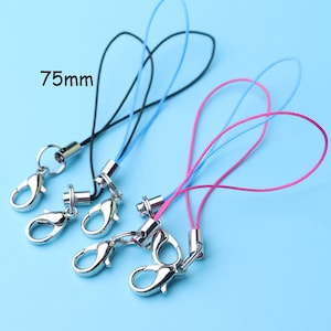 May include: A collection of colorful lanyards with metal lobster clasps. The lanyards are black, blue, and pink, with a silver-colored metal clasp. The text "75mm" is visible in the image. The background is a light blue.