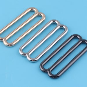 Peut inclure: Trois boucles coulissantes en métal, dorées, argentées et noires.