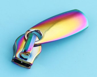 May include: A rainbow iridescent zipper pull with a metal slider and a loop. The pull is made of metal and has a smooth, shiny finish.