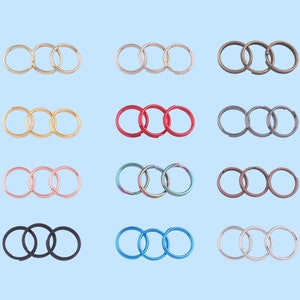May include: A set of 10 key rings in various colors, including silver, gold, red, blue, black, and rainbow. Each key ring is made of metal and has three interlocking rings.
