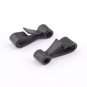 May include: Two black plastic clasps with a hook and a loop. The clasps are designed to be used for securing items together.