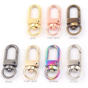 May include: Assortment of 10 metal swivel clasps in various colors, including gold, rose gold, bronze, black, light gold, rainbow, and silver. Each clasp features a swivel hook and a D-ring.