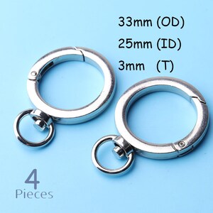 May include: Four silver key rings with a spring-loaded clasp. The rings are 33mm in outer diameter, 25mm in inner diameter, and 3mm thick.
