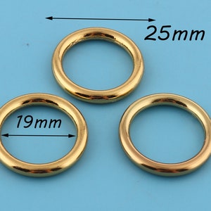 May include: Three gold metal rings, one measuring 19 mm in diameter and two measuring 25 mm in diameter.