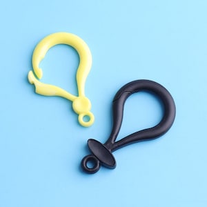 May include: Two plastic keyrings, one yellow and one black. Both keyrings have a loop at the top and a hook at the bottom.