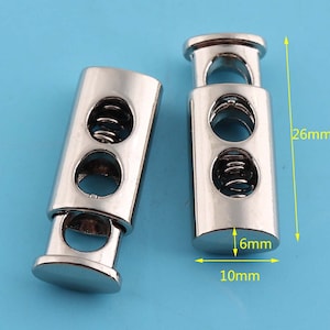 Puede incluir: Dos cierres de palanca de metal plateado con mecanismos de resorte. Cada cierre mide 26 mm de largo, 10 mm de ancho y 6 mm de diámetro.