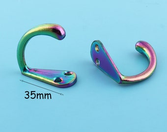 May include: Two iridescent rainbow-colored metal hooks. The hook on the left is 35mm wide. Both hooks have a rounded shape and a flat base.