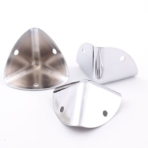 Puede incluir: Tres soportes de esquina plateados para muebles. Cada soporte tiene tres agujeros para sujetarlo a los muebles.