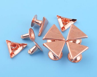 May include: A set of eight copper-colored triangle-shaped metal studs with a hole in the center. The studs have a flat back and a raised, rounded top.
