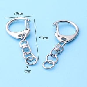 May include: Two silver keychains with a 20 mm ring and a 50 mm chain. The chain is 8 mm wide.