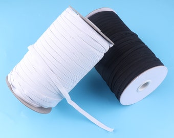 May include: Two spools of elastic cord, one white and one black, are wound around cardboard spools. The spools are on a blue background.