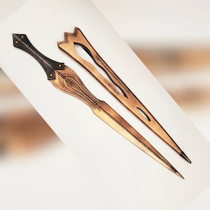 Könnte beinhalten: Ein Set aus zwei dekorativen Brieföffnern. Einer ist ein schwarzer und goldener Brieföffner aus Metall mit einem dekorativen Design. Der andere ist ein goldener Brieföffner aus Metall mit einem dekorativen Design und dem Text "Sie haben uns umzingelt, aber wir sind in der Überzahl, und wir haben die hohe Position." und "Die Chancen sind nie zu unseren Gunsten."
