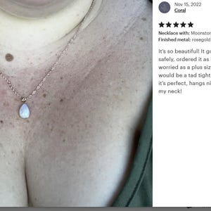 May include: A silver chain necklace with a teardrop-shaped moonstone pendant. The necklace is worn by a person with a larger chest size. The necklace is described as being perfect and hangs nicely around the neck.