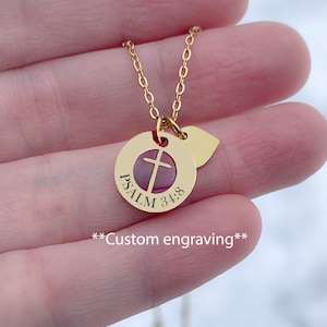 Op de afbeelding: Gouden ketting met een ronde hanger met een kruis en de tekst "PSALM 34:8". De hanger is bevestigd aan een klein hartvormig bedeltje. **Aangepaste gravure** staat onder de hanger.