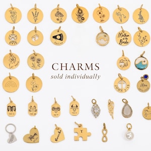 May include: A collection of gold-toned metal charms featuring various engraved designs including flowers, zodiac signs, names, and symbols. The charms are round, heart-shaped, rectangular, or unique shapes, each with a small jump ring for attachment.