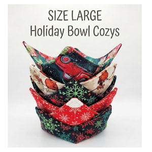 May include: A stack of four fabric bowl cozys in size large, featuring holiday patterns including a red truck, birds, and snowflakes in red, green, black, and cream colors. The text "SIZE LARGE Holiday Bowl Cozys" is printed above the stack.