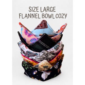 May include: A stack of large flannel bowl cozies featuring various colorful patterns including butterflies, floral motifs, and celestial designs. The text "SIZE LARGE FLANNEL BOWL COZY" is printed in dark brown letters above the fabric items.