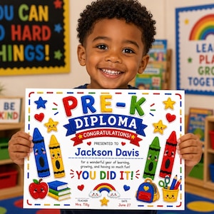 Könnte beinhalten: Ein lächelndes Kind hält ein farbenfrohes Pre-K-Diplom. Das Diplom zeigt den Text "PRE-K DIPLOMA CONGRATULATIONS!" mit Buntstiftillustrationen, Sternen, Herzen und dem Namen des Kindes. Der Hintergrund umfasst Klassenzimmerdekorationen.